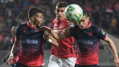 Wydad's Hamza Asrir and Abdellatif Noussir attempt to block Etoile's Karim Aribi during the CAF Champions League quarter-final between Tunisia's Etoile du Sahel and Morocco's Wydad Casablanca.