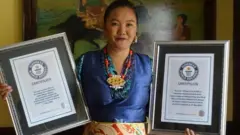 Lhakpa Sherpa holding Guinness World Record certificates in frames