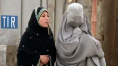 A burqa-clad woman and a girl on a street in Kandahar on 5 March 2022