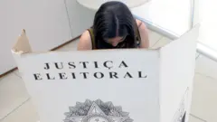 Eleitora em cabina de votação