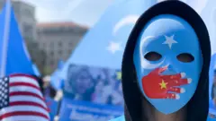 A demonstrator, wearing a mask with a Chinese flag on a hand over the mouth, protests in Washington