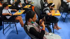 student with mobile in the classroom
