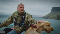 Meštanin ostrva na čamcu sa psom