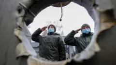 Des membres de la Garde nationale ukrainienne assistent à une cérémonie en hommage aux défenseurs de l'Ukraine tombés au champ d'honneur, y compris les soldats tués dans le conflit militaire avec les rebelles pro-russes dans les régions orientales du pays, à un mémorial situé à l'extérieur du siège du ministère de la Défense à Kiev, en Ukraine, le 28 janvier 2022