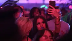 Une jeune femme filme à la soirée de lancement de TikTok