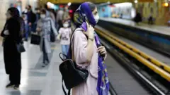 Iranian woman waiting on metro platform in Tehran