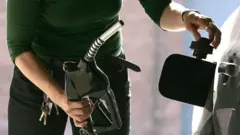 امرأة تملئ سيارتها بالوقود