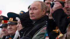 Russian President Vladimir Putin watches a military parade on Victory Day, which marks the 77th anniversary of the victory over Nazi Germany in World War Two, in Red Square in central Moscow, Russia May 9, 2022.