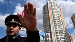 Полицейский рядом с пострадавшим от дрона домом