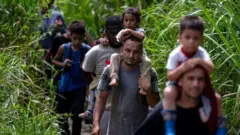 Migrantes em Darien, andando em meio à vegetação