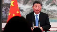 上海中國國際進口博覽會媒體中心內記者觀看大屏幕上播放的中國國家主席習近平演說（4/11/2021）