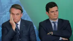 Bolsonaro e Moro sentados em evento, olhando para sentidos opostos