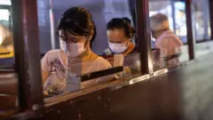 Pessoas de máscara de cabeça baixa no ônibus