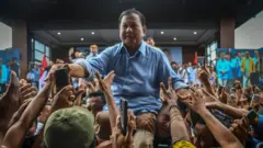 Calon presiden nomor urut 2 Prabowo Subianto (tengah) menyalami warga saat melakukan kampanye di acara konsolidasi tokoh agama dan masyarakat di Pool Primajasa, Tasikmalaya, Jawa Barat, Sabtu (2/12/2023).