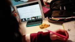 young person studies at home with other students through the Tablet