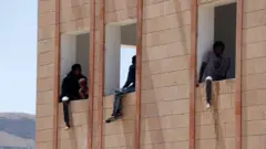 مهاجرون إثيوبيون داخل مبنى أثناء خضوعهم للحجر الصحي خلال عبورهم أراضي اليمن للوصول إلى السعودية