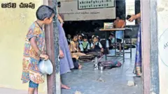 స్కూలు వద్ద భోజనం కోసం వేచి ఉన్న చిన్నారి