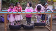 Vietnamese girls play on a obstacle course made of tyres.
