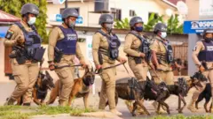 Police dey on ground with sniffing dogs