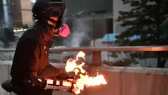 A protester prepares to throw a molotov cocktail towards police in the Admiralty area
