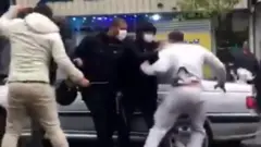 Screengrab of video appearing to show a man being detained during a protest in Tehran, Iran