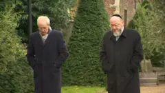 聖公會坎特伯雷大主教韋爾比（左）與英聯邦猶太教首席拉比米爾維斯（右）在倫敦蘭柏宮內踱步