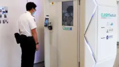 হংকং বিমানবন্দরে যাত্রীর পুরো শরীর ও পোশাক জীবাণুমুক্ত করার যন্ত্র