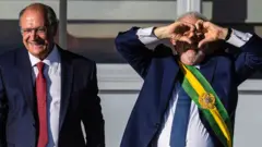 Alckmin e Lula sorrindo, em pé, durante cerimônia da posse
