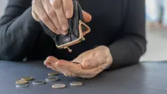 سيدة تحصي ما تبقى لديها من نقود