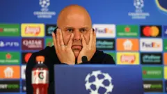 Liverpool Teknik Direktörü Arne Slot, maçın ardından düzenlenen basın toplantısında konuşuyor. Ellerini yüzüne yaslamış, endişeli görünüyor.