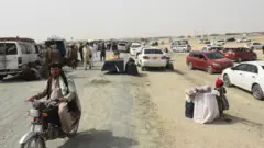 تجمع الأشخاص الذين تقطعت بهم السبل في بلدة شامان الحدودية الباكستانية في 14 يوليو 2021، بعد أن زعمت حركة طالبان أنها استولت على الجانب الأفغاني من معبر سبين بولداك الحدودي على طول الحدود مع باكستان.