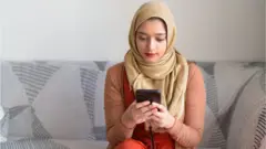 Woman sitting on a sofa and looking at her mobile phone