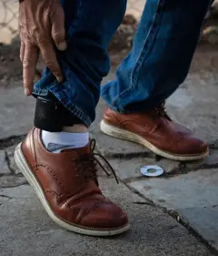 Retrato de perna com tornozeleira eletrônica