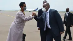 Gen Muhoozi aramutsa umwe mu bakozi ba ambasade ya Uganda i Kigali