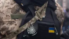 A detail of the black sun that appears on the uniform of a Ukrainian soldier