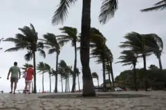 Banhistas andam na praia do Arpoador, no Rio de Janeiro, em meio a ventos fortes