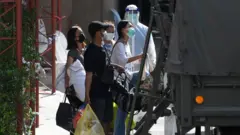 เจ้าหน้าที่เขตคลองเตยเคลื่อนย้ายผู้ป่วยติดเชื้อโรคโควิด-19 ในชุมชนคลองเตยไปยังโรงพยาบาลสนามเมื่อวันที่ 29 เม.ย. ที่ผ่านมา