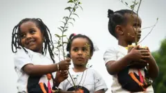 మొక్కలు నాటుతున్న చిన్నారులు