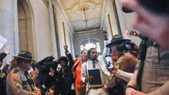 Tennessee Representatives Justin Pearson, Gloria Johnson and Justin Jones walk through a crowd of supporters at the Tennessee State Capitol as Republicans who control the Tennessee House of Representatives prepare to vote on whether to expel three Democratic members for their role in a gun control demonstration at the state House last week