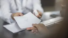 Médico entrega atestado para paciente