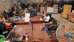 Les travailleurs scannent les produits pour les livrer à l'entrepôt Ikeja de l'entreprise à Lagos.