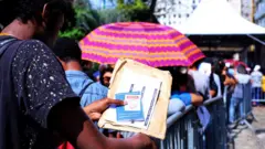 Jovem na fila do mutirão do emprego em São Paulo