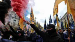 Members of the nationalist movements hold burning flares during the March of the Nation to the Day of Defender of Ukraine