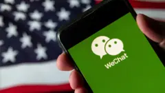設計圖片：手機上的微信圖標（前）與美國國旗（後）