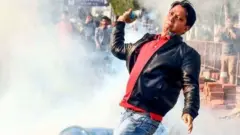 ટિયર ગેસ ફેંકી રહેલા યુવકની તસવીર