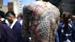 Participant with Japanese tattoo is seen in the street of Asakusa during Sanja Festival on May 19, 2019 in Tokyo, Japan