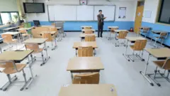 전국 유치원과 초·중·고교 개학을 2주 추가 연기한 17일 전북 전주시 서곡중학교에 선생님들이 책걸상을 일렬로 배치하고 있다