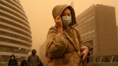 Pedestres em meio a tempestade de areia na China