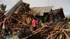 Residents salvage belongings from their destroyed homes in the coastal town of Dulag, Philippines