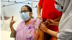 ঢাকার একটি হাসপাতালে ফাইজারের টিকা নিয়ে বিজয় চিহ্ন দেখাচ্ছেন এই টিকা গ্রহীতা।